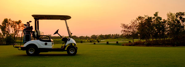 empty golf cart on golf course at sunset
