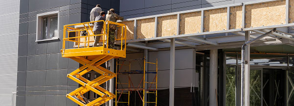 people working at a construction site using an industrial lift
