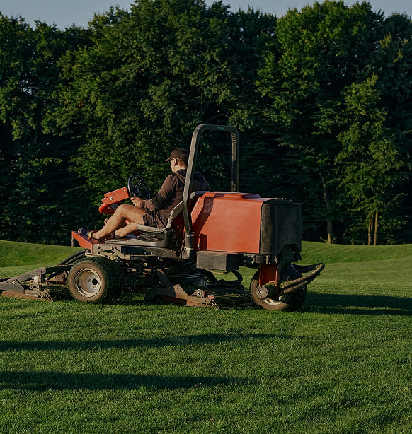 person riding lawn mower